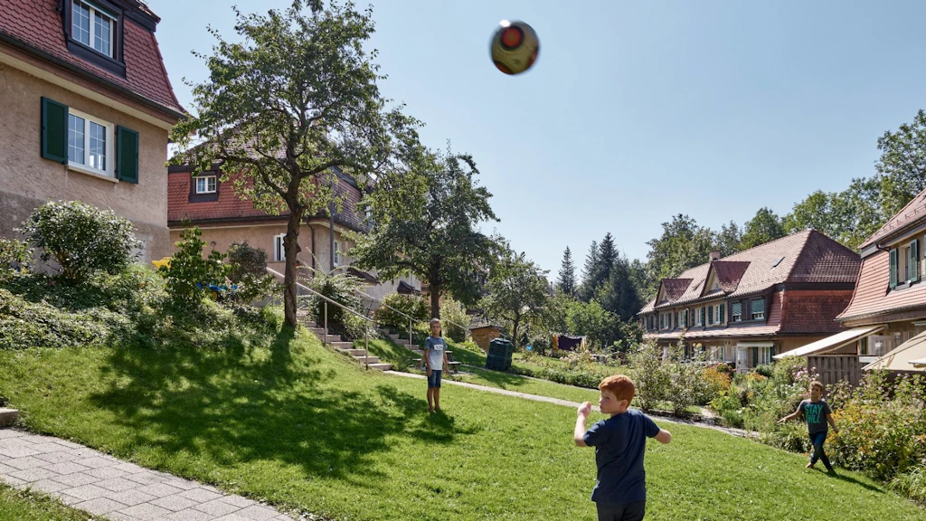 Das Bild zeigt spielende Kinder in der Siedlung Schoren in St. Gallen. Diese wurde 1911–1914 von der Eisenbahner-Genossenschaft gebaut.