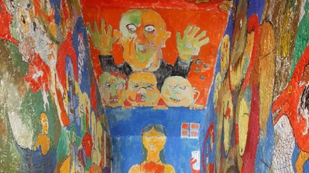 Besucherblick in die von Friedrich Dürrenmatt farbenfroh ausgemalte Toilette seines Wohnhauses in Neuenburg: Enge Kabine mit vollständig bemalten Wänden, auf denen expressive Fratzen, Figuren und Szenen in leuchtenden Farben erscheinen. Von Dürrenmatt scherzhaft „Sixtinische Kapelle“ genannt, ist der Raum heute Teil des Centre Dürrenmatt.