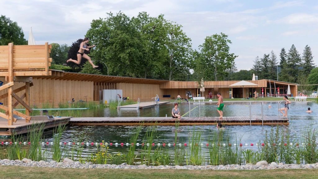 Das 2014 von Herzog & de Meuron errichtete Naturbad Riehen zeichnet sich aus durch Gebäude aus unbehandeltem Lärchenholz und einem naturnahen Schwimmbecken mit ökologischer Wasseraufbereitung. 
