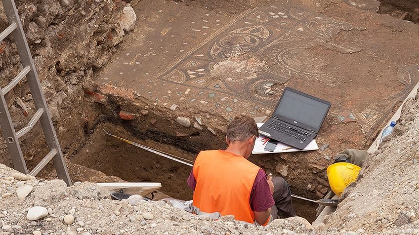 Das Bild zeigt zwei Archäologen bei ihrer Arbeit an einer archäologischen Fundstelle in Avenches (VD).